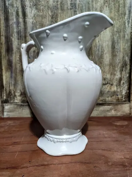 Foto de um(a) Jarra em porcelana, da categoria de Garrafas, potes e jarros. Jarra em porcelana com detalhes em relevo. A: 26cm Diâmetro: 25cm Peso: 1,250kg. Mostrado de uma perspectiva diferente. Vendido no marketplace Trésors.