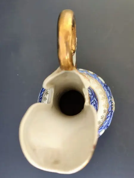 Foto de um(a) Pequena Jarra Blue anos 40, Indústria Brasileira, da categoria de Jarros. Pequena jarra em porcelana com pintura azul cobalto e amarelo perolado, filetada com ouro e grega com trevos também ouro... Mostrado de uma perspectiva diferente. Vendido no marketplace Trésors.