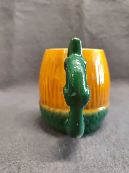 Foto de um(a) Caneco Porcelana em Formato de Nozes e Esquilo, Cerâmica Guarani, Década de 1940, da categoria de Canecas. Caneco porcelana laranja e verde com a forma de noz e esquilo como alça, década de 194. Fabricante: cerâmica guarani A: 11... Mostrado de uma perspectiva diferente. Vendido no marketplace Trésors.