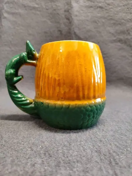 Foto de um(a) Caneco Porcelana em Formato de Nozes e Esquilo, Cerâmica Guarani, Década de 1940, da categoria de Canecas. Caneco porcelana laranja e verde com a forma de noz e esquilo como alça, década de 194. Fabricante: cerâmica guarani A: 11... Mostrado de uma perspectiva diferente. Vendido no marketplace Trésors.