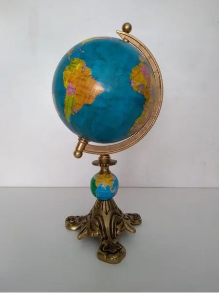 Foto de um(a) Globo Globinho, da categoria de Globos. Globo terrestre de mesa em latão fundido e pátina dourada A: 28cm Peso: 587g. Mostrado de uma perspectiva diferente. Vendido no marketplace Trésors.