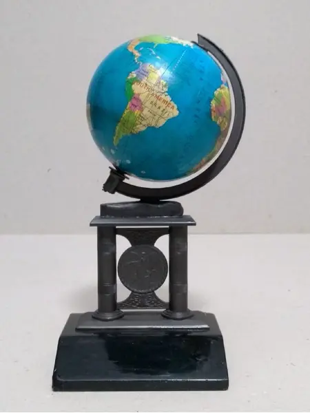 Foto de um(a) Globo Granito, da categoria de Globos. Globo com base em latão oxidado e granito preto. A: 17cm Base: 9 x 7cm Peso: 472g. Mostrado de uma perspectiva diferente. Vendido no marketplace Trésors.