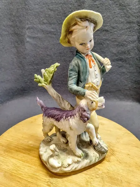 Foto de um(a) Biscuit Italiano Menino e Cão, Década de 1980, da categoria de Modelos e estatuetas. Biscuit italiano policromada dos anos 1980. A: 23 cm / L: 11 cm / P: 15 cm / Peso: 650 g. Mostrado de uma perspectiva diferente. Vendido no marketplace Trésors.