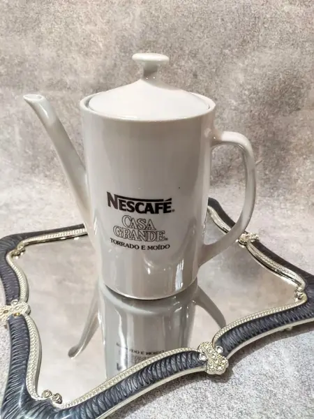 Foto de um(a) Bule Nescafé Porcelana Pozzani 70'S, da categoria de Bules. Bule de café em porcelana branca com a marca da nescafé em marrom, década de 1970 marca do fabricante: pozzani, peça... Mostrado de uma perspectiva diferente. Vendido no marketplace Trésors.