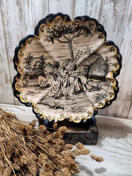 Foto de um(a) Prato Terracota Cena Campestre anos 40, da categoria de Pratos Decorativos. Prato em terracota esmaltado, pintado à mão nas cores bege, preto, cinza e amarela com arabescos na borda e oito gomos. Cena... Mostrado de uma perspectiva diferente. Vendido no marketplace Trésors.