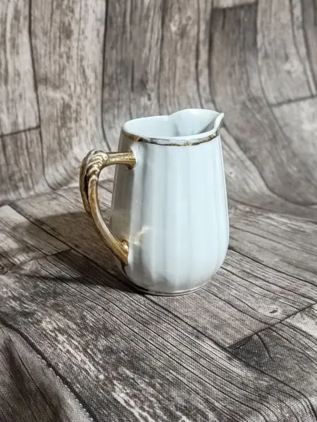 Foto de um(a) Cremeira Porcelana Branca Filetada a Ouro, Década de 1970, da categoria de Cremeiras. Cremeira em porcelana branca canelada com filete, alça e bico em ouro, década de 1970 sem marca do fabricante. A: 9cm L alça... Mostrado de uma perspectiva diferente. Vendido no marketplace Trésors.
