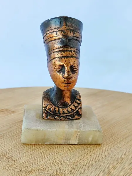 Foto de um(a) Escultura Nefertiti, Década de 1970, da categoria de Escultura. Nefertiti: escultura em cobre maciço com base em mármore. Comprada no cairo na década de 1970. A: 9,5 cm / L: 3,5 cm / P: 6... Mostrado de uma perspectiva diferente. Vendido no marketplace Trésors.