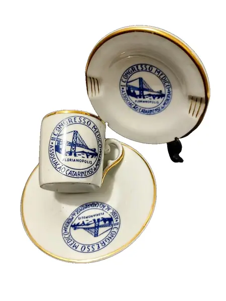 Foto de um(a) Conjunto Cafézinho e Cinzeiro, II Congresso Médico em Florianópolis, Porcelana Schmidt, Anos 2000, da categoria de Xícaras. Xícara de cafézinho e cinzeiro com logo do II congresso médico em florianópolis: porcelana schmidt com filete em ouro e logo... Vendido no marketplace Trésors.