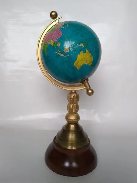 Foto de um(a) Globo Torneado, da categoria de Globos. Globo terrestre com base em madeira torneada e latão e haste dourada. A: 26cm D globo: 10cm D base: 10cm. Mostrado de uma perspectiva diferente. Vendido no marketplace Trésors.