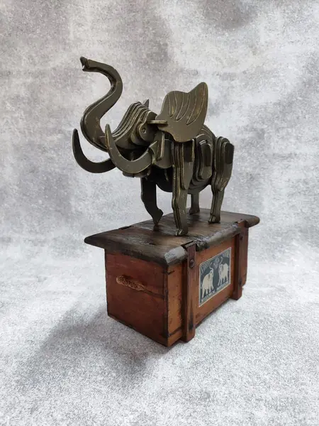 Foto de um(a) Caixa Container Elefante, Década de 1940, da categoria de Cestos e Caixas. Contêiner elefante: caixa de madeira com tampa de elefante em compensado com corte computadorizado com pátina bronze... Mostrado de uma perspectiva diferente. Vendido no marketplace Trésors.
