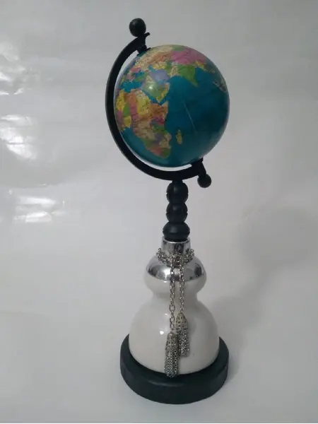 Foto de um(a) Globo Terrestre Porcelana, da categoria de Globos. Globo terrestre com base em madeira e porcelana, pendente em metal. A: 32 cm D base: 11,5 cm D globo: 9 cm peso: 845g. Mostrado de uma perspectiva diferente. Vendido no marketplace Trésors.