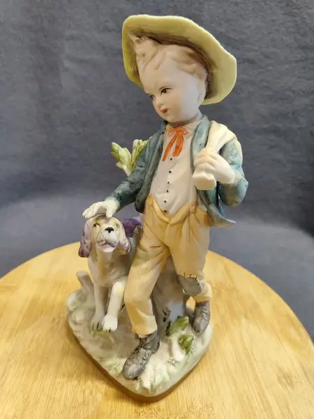 Foto de um(a) Biscuit Italiano Menino e Cão, Década de 1980, da categoria de Modelos e estatuetas. Biscuit italiano policromada dos anos 1980. A: 23 cm / L: 11 cm / P: 15 cm / Peso: 650 g. Mostrado de uma perspectiva diferente. Vendido no marketplace Trésors.