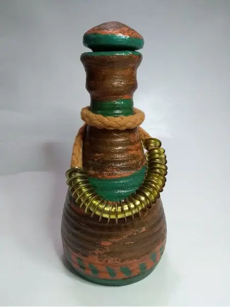 Foto de um(a) Moringa de barro, da categoria de Garrafas, potes e jarros. Moringa de barro com tampa policromada, colar de algodão e latão. A: 22cm Diâmetro: 10cm peso: 697g. Mostrado de uma perspectiva diferente. Vendido no marketplace Trésors.