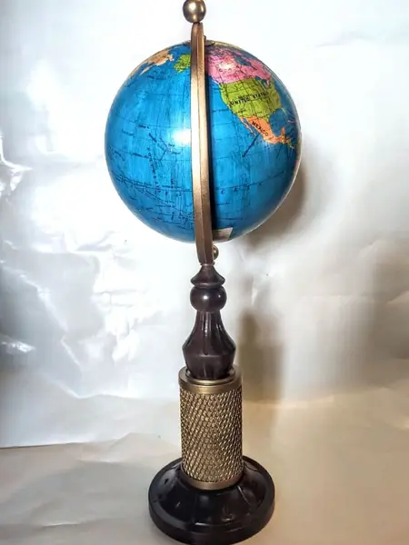 Foto de um(a) Globo Terrestre Dourado, da categoria de Globos. Globo terrestre com base em imbuia torneada e entalhada, tendo como foco central uma vela de filtro d'água em dourado. Mais... Mostrado de uma perspectiva diferente. Vendido no marketplace Trésors.
