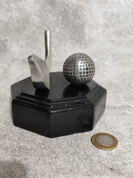 Foto de um(a) Escultura Golfe em Alumínio Fundido, Década 2015, da categoria de Modelos e estatuetas. Escultura de mesa com taco e bola de golfe em alumínio fundido e oxidado, base em madeira oitavada ebanizada. Procedência... Mostrado de uma perspectiva diferente. Vendido no marketplace Trésors.