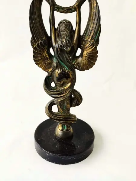 Foto de um(a) Escultura Anjo da Vitória, da categoria de Escultura. Escultura anjo da vitória com coroa de louro e base em granito, década de 1940. A: 34cm / L: 11cm D base: 12,5cm peso:... Mostrado de uma perspectiva diferente. Vendido no marketplace Trésors.