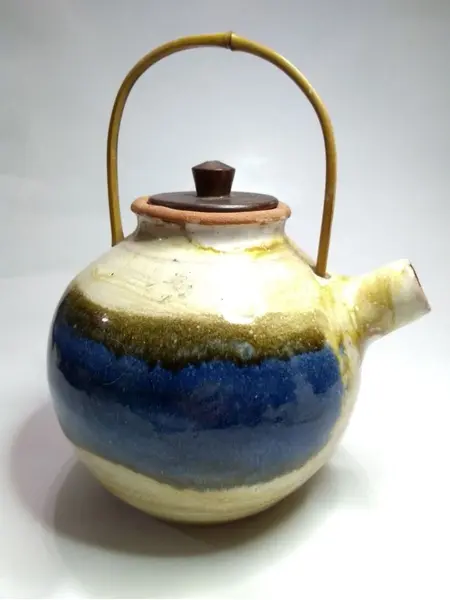 Foto de um(a) Chaleira Diferentona, da categoria de Chaleiras. Chaleira em terracota esmaltada com alça em bambu e tampa em madeira. A: 15cm Diâmetro: 13cm Peso: 730g. Mostrado de uma perspectiva diferente. Vendido no marketplace Trésors.