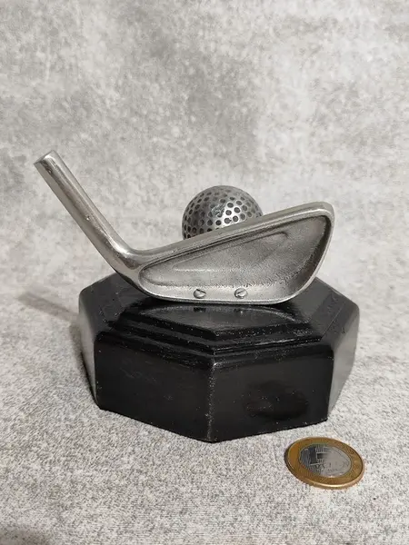 Foto de um(a) Escultura Golfe em Alumínio Fundido, Década 2015, da categoria de Modelos e estatuetas. Escultura de mesa com taco e bola de golfe em alumínio fundido e oxidado, base em madeira oitavada ebanizada. Procedência... Mostrado de uma perspectiva diferente. Vendido no marketplace Trésors.
