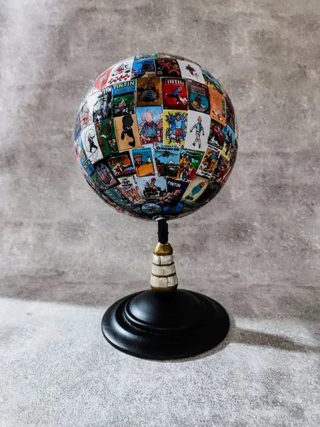 Foto de um(a) Globo Tintim, Herge, da categoria de Globos. Globo tintim globo com esfera giratória de plástico decoupado com imagens do tintim, estrutura em ferro com detalhes em... Mostrado de uma perspectiva diferente. Vendido no marketplace Trésors.