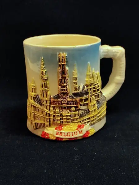 Foto de um(a) Caneca Belga em Cerâmica, Souvenir de 1999, da categoria de Canecas. Caneca belga em cerâmica com relevo e policromia feita a mão: apresentando marcos arquitetônicos da cidade de bruxelas e... Mostrado de uma perspectiva diferente. Vendido no marketplace Trésors.