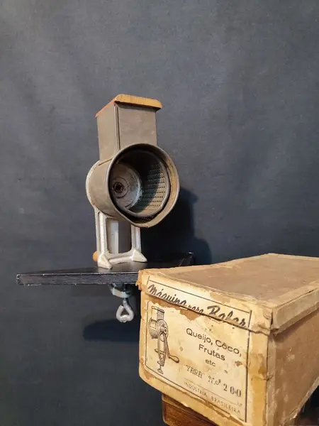 Foto de um(a) Ralador de Queijo e Frutas, Marca Yara N.200, Década de 1940, da categoria de Acessórios de cozinha. Máquina de ralar queijo, coco e frutas. Em ferro, folha de flanders e socador e manivela em madeira, com embalagem original... Mostrado de uma perspectiva diferente. Vendido no marketplace Trésors.