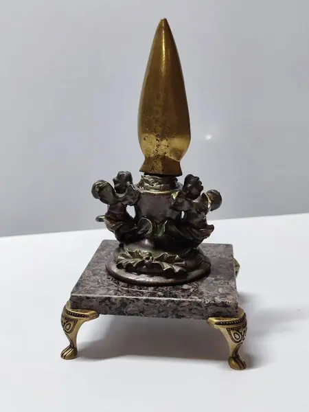 Foto de um(a) Escultura de Mesa Ponta de Lança e Anjos, Peça Única, Década de 2000, da categoria de Escultura. Escultura de mesa: ponta de lança em latão polido segurada por anjos de resina com pátina bronze oxidada, base em granito... Mostrado de uma perspectiva diferente. Vendido no marketplace Trésors.