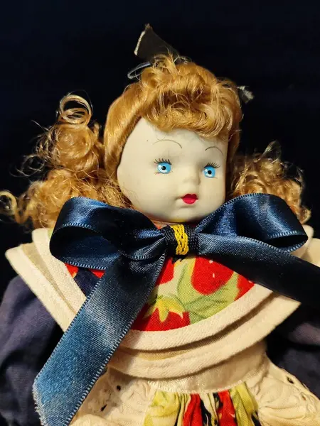 Foto de um(a) Boneca Porcelana e Tecido, Per Bambino, Década de 1990, da categoria de Bonecas. Boneca com membros e cabeça em porcelana, corpo em tecido/enchimento. Vestido original, cabelos de vinil e acompanha suporte... Mostrado de uma perspectiva diferente. Vendido no marketplace Trésors.