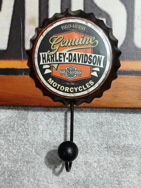 Foto de um(a) Cabideiro Harley-Davidson, da categoria de Cabideiros e porta-chapéus. Cabideiro de parede com logo da harley-davidson. Madeira de cerejeira e com ganchos lembrando tampas de garrafas com logo da... Mostrado de uma perspectiva diferente. Vendido no marketplace Trésors.