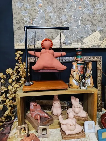 Foto de um(a) Escultura Feminina em Terracota, Peça Única, da categoria de Escultura. Escultura feminina em terracota no balanço, cabelos são de contas na cor coral, balanço em ferro com madeira e base com pés... Mostrado de uma perspectiva diferente. Vendido no marketplace Trésors.