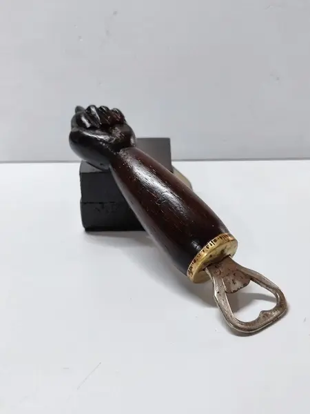 Foto de um(a) Figa Abridor de Garrafa em Madeira, Decada de 1990, da categoria de Abridores de garrafas. Figa abridor de garrafa esculpida em madeira com base para apoio com uma placa em metal, decada de 1990 Mede: 18 x 7cm. Mostrado de uma perspectiva diferente. Vendido no marketplace Trésors.