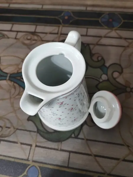 Foto de um(a) Bule e Açucareiro Porcelana Real, Década de 1990, da categoria de Bules. Combo com bule e açucareiro em porcelana branca e estampa de flores em rosa e cinza. Bule com trava na tampa e tranca pingo.... Mostrado de uma perspectiva diferente. Vendido no marketplace Trésors.