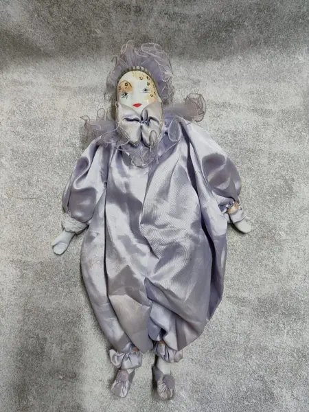 Foto de um(a) Pierrot em Porcelana, Década de 1970, da categoria de Bonecas. Pierrô em porcelana com vestimentas em cetim na cor lilás, corpo em tecido com enchimento e membros móveis. Cabeça com tiara... Mostrado de uma perspectiva diferente. Vendido no marketplace Trésors.