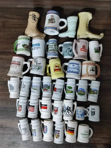 Foto de um(a) Combo 36 Mini Canecos de Chopp, da categoria de Canecas. Canecos de chopp miniatura em porcelana policromada. Coleção composta por 36 exemplares, com indicação de eventos, bandeiras... Mostrado de uma perspectiva diferente. Vendido no marketplace Trésors.