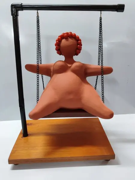 Foto de um(a) Escultura Feminina em Terracota, Peça Única, da categoria de Escultura. Escultura feminina em terracota no balanço, cabelos são de contas na cor coral, balanço em ferro com madeira e base com pés... Mostrado de uma perspectiva diferente. Vendido no marketplace Trésors.