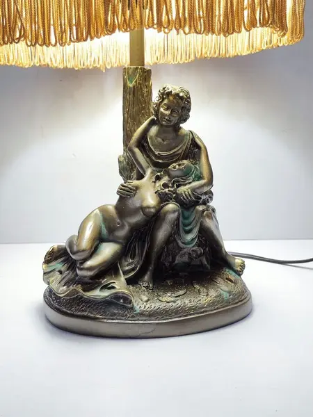 Foto de um(a) Abajur Cena Galante em Resina Italiana, da categoria de Abajures. Abajur cena galante em resina italiana com pátina bronze envelhecida e oxidada, cúpula gomada com tecido cru e passamanaria... Mostrado de uma perspectiva diferente. Vendido no marketplace Trésors.