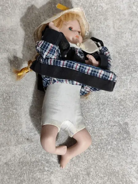 Foto de um(a) Bonequinha de Porcelana, Década de 2000, da categoria de Bonecas. Boneca de porcelana representando um bebê engatinhando, com rosto policromado, corpo em tecido e enchimento, chapéu de ráfia... Mostrado de uma perspectiva diferente. Vendido no marketplace Trésors.