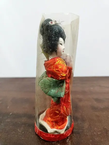 Foto de um(a) Pequena Gueixa Japonesa, Década de 1960, da categoria de Modelos e estatuetas. Pequena gueixa com seu quimono original dos anos 1960. Ainda com a embalagem. A: 12 cm / Diâmetro: 4,6 cm / Peso: 38 g. Mostrado de uma perspectiva diferente. Vendido no marketplace Trésors.