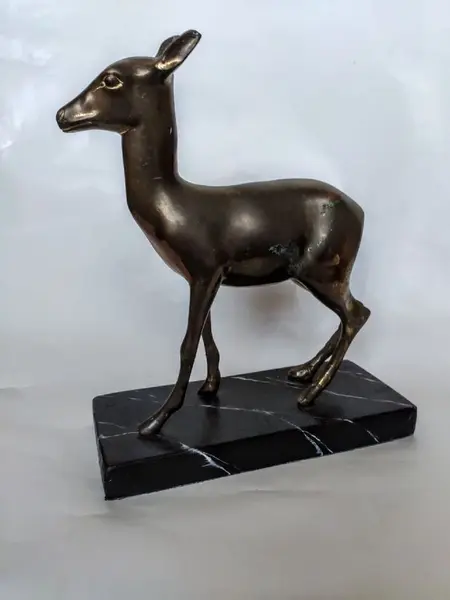 Foto de um(a) Escultura Cervo em Bronze, da categoria de Escultura. Cervo em bronze com base em madeira marmorizada, década de 1930. A: 24cm / P: 6cm / L: 19cm Base: 21 x 9 x 2cm. Mostrado de uma perspectiva diferente. Vendido no marketplace Trésors.