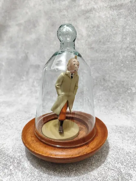 Foto de um(a) As Aventuras de Tintim, Hergé, com Redoma de Vidro, da categoria de Memorabilia de mídia e entretenimento. Tintim com capa de chuva, do livro o caranguejo das pinças de ouro. Figura icônica do seu criador hergé no ano de 1926. A:... Mostrado de uma perspectiva diferente. Vendido no marketplace Trésors.