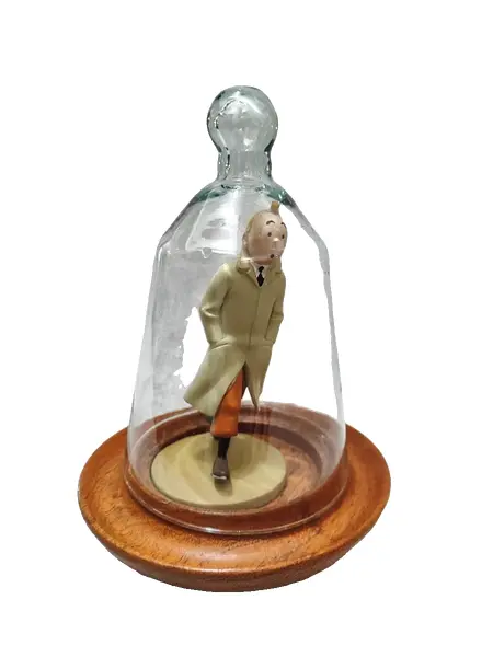 Foto de um(a) As Aventuras de Tintim, Hergé, com Redoma de Vidro, da categoria de Memorabilia de mídia e entretenimento. Tintim com capa de chuva, do livro o caranguejo das pinças de ouro. Figura icônica do seu criador hergé no ano de 1926. A:... Vendido no marketplace Trésors.
