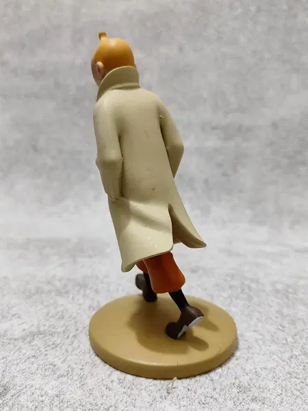 Foto de um(a) As Aventuras de Tintim, Hergé, com Redoma de Vidro, da categoria de Memorabilia de mídia e entretenimento. Tintim com capa de chuva, do livro o caranguejo das pinças de ouro. Figura icônica do seu criador hergé no ano de 1926. A:... Mostrado de uma perspectiva diferente. Vendido no marketplace Trésors.