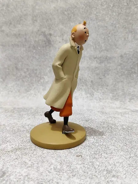 Foto de um(a) As Aventuras de Tintim, Hergé, com Redoma de Vidro, da categoria de Memorabilia de mídia e entretenimento. Tintim com capa de chuva, do livro o caranguejo das pinças de ouro. Figura icônica do seu criador hergé no ano de 1926. A:... Mostrado de uma perspectiva diferente. Vendido no marketplace Trésors.