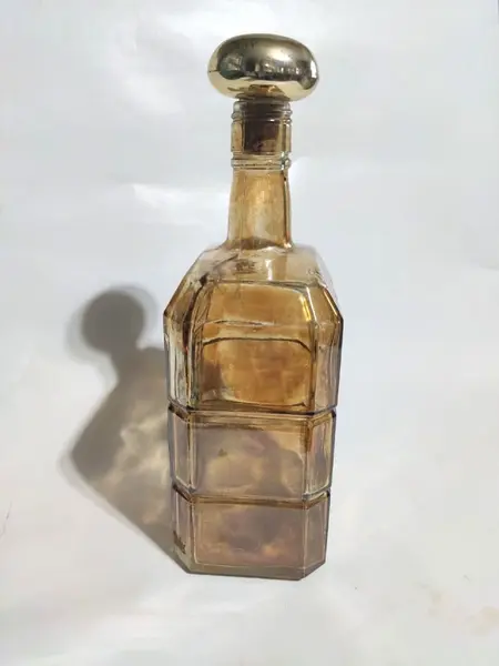 Foto de um(a) Garrafa Âmbar 70'S, da categoria de Garrafas, potes e jarros. Garrafa âmbar com pintura floral em dourado, década de 1970.A: 24,5 cm L: 11 cm P: 8 cm / peso: 765 g. Mostrado de uma perspectiva diferente. Vendido no marketplace Trésors.