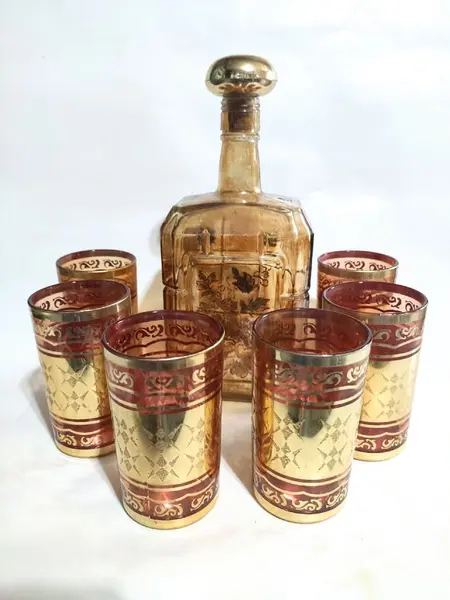 Foto de um(a) Conjunto Indiano Anos 70, da categoria de Jogos de taças e copos. Conjunto indiano e folheado a ouro, 6 copos em vidro (made in korea) e 1 garrafa em cristal âmbar com pintura floral para... Mostrado de uma perspectiva diferente. Vendido no marketplace Trésors.