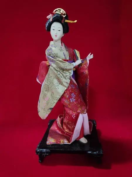 Foto de um(a) Gueixa em Porcelana, Década de 1970, da categoria de Modelos e estatuetas. Gueixa com cabeça, mãos e pé de porcelana vestindo sua indumentária característica, base em madeira com pezinhos em latão... Mostrado de uma perspectiva diferente. Vendido no marketplace Trésors.
