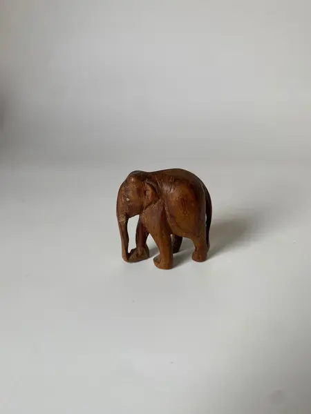 Foto de um(a) Escultura de elefante, da categoria de Modelos e estatuetas. Pequeno elefante esculpido na madeira Mede: 6 x 5 cm. Mostrado de uma perspectiva diferente. Vendido no marketplace Trésors.