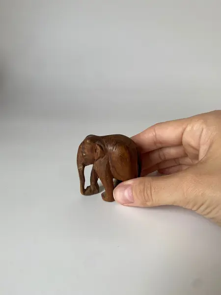 Foto de um(a) Escultura de elefante, da categoria de Modelos e estatuetas. Pequeno elefante esculpido na madeira Mede: 6 x 5 cm. Mostrado de uma perspectiva diferente. Vendido no marketplace Trésors.
