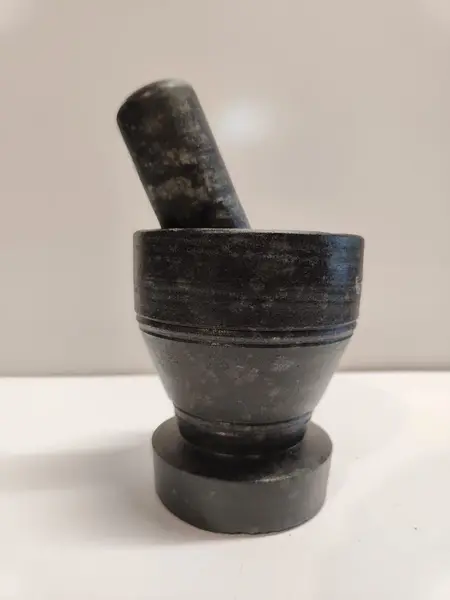 Foto de um(a) Pilão de Mesa em Pedra Sabão, da categoria de Outros utensílios. Pilão de mesa com socador em pedra sabão protegido com óleo mineral, um aliado da culinária mineira. A: 11,5 cm Diâmetro... Mostrado de uma perspectiva diferente. Vendido no marketplace Trésors.
