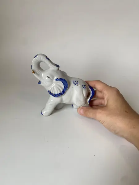Foto de um(a) Bibelô de elefante, da categoria de Modelos e estatuetas. Bibelô elefante em porcelana 13 cm altura, 13 cm diâm. Mostrado de uma perspectiva diferente. Vendido no marketplace Trésors.
