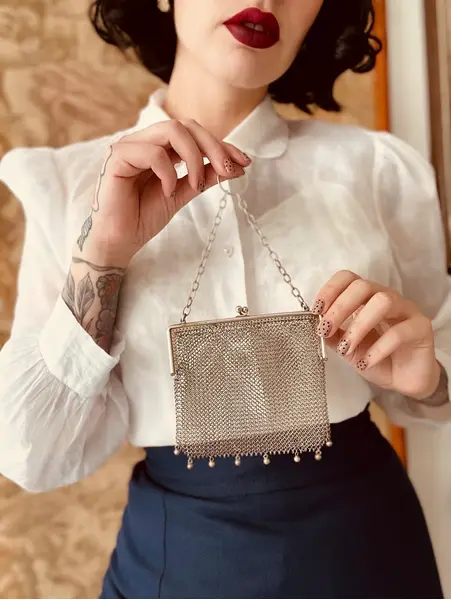 Foto de um(a) Bolsa Malha Prata Portuguesa, da categoria de Arte têxtil. Bolsa de toalete portuguesa em prata contrastada, década de 1920. Corpo em malha de prata artesanal, com delicados pingentes... Mostrado de uma perspectiva diferente. Vendido no marketplace Trésors.